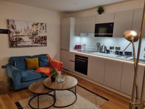 圣奥尔本斯Ritual Stays stylish 1-Bed Flat in the Heart of St Albans City Centre with Working Space and Super Fast WiFi的客厅配有蓝色的沙发和桌子