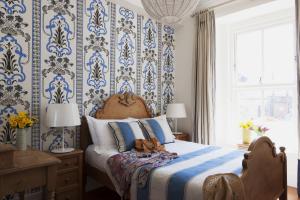 邓莫尔东The Townhouse Strand的一间卧室配有蓝色和白色壁纸的床