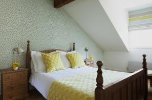 邓莫尔东The Townhouse Strand的一间卧室配有黄色和白色枕头的床