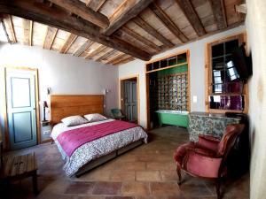 布尔邦LA CASA DE BOULBON的一间卧室配有一张床和一把椅子