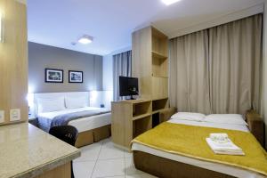 弗洛里亚诺波利斯Interclass Florianópolis的酒店客房设有两张床和电视。