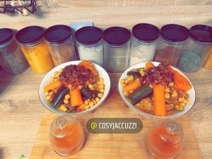 奥朗日Cosy jacuzzi的一张桌子,上面有三盘带胡萝卜和豆子的食物