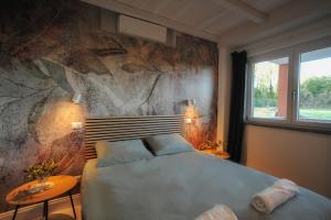 维泰博Tenuta Bussete Country Hotel的一间卧室设有一张床和石墙