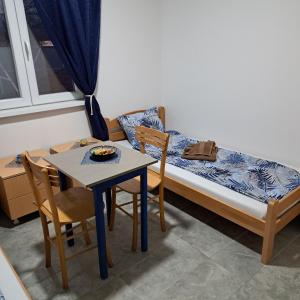 SurčinLIBERO APARTMANI的小房间设有一张床、一张桌子和椅子