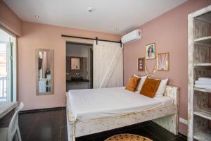 威廉斯塔德BOHO Bohemian Boutique Hotel的一间卧室配有带白色床单和橙色枕头的床。