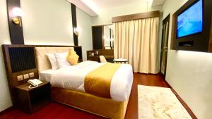 迪拜Concorde Inn Hotel的酒店客房,配有床和电视