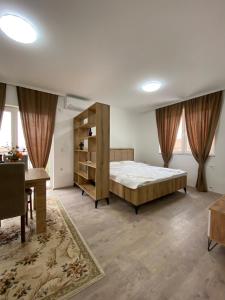 Kosovo PoljeWhite Apartments的一间卧室配有一张大床和一张书桌