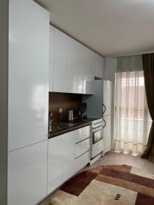 Kosovo PoljeWhite Apartments的厨房配有白色橱柜和炉灶。