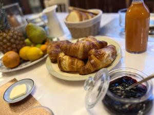 富热尔Mercier de Montigny - Les Chambres du Beffroi - SPA et Massage的餐桌上摆放着羊角面包和其他早餐食品