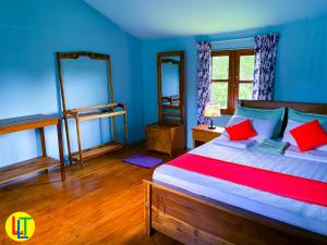 Nekattegamamango villa wilpattu的一间卧室配有一张带蓝色墙壁和红色枕头的床