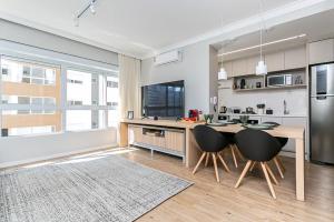 圣若泽K-Platz 406 - Studio Elegante e Moderno na Melhor Localização do Continente的厨房配有桌椅和冰箱。