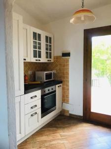 奥尔比亚Sealine Villa with an amazing view of Tavolara的厨房配有白色橱柜和炉灶烤箱。