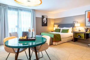 库尔布瓦Fraser Suites Paris La Défense的酒店客房配有一张床铺和一张桌子。