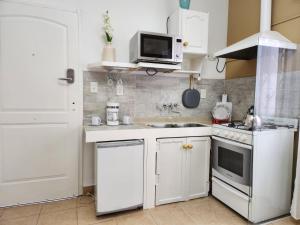 马丁内斯Jazmines Apart的小厨房配有白色橱柜和微波炉