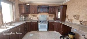 瓦迪穆萨noor apartment的厨房配有木制橱柜和炉灶烤箱。