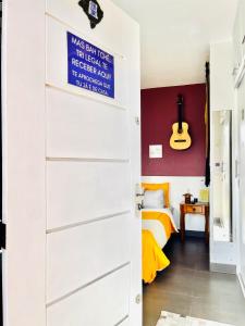 阿雷格里港La Casita Bem Gaúcha的通往卧室的门,卧室配有一张床和吉他