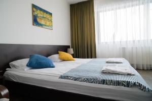 萨基爱伊Jundula的一间卧室配有一张带蓝色和黄色枕头的大床