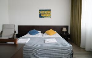 萨基爱伊Jundula的一间卧室配有一张带色彩缤纷枕头的大床