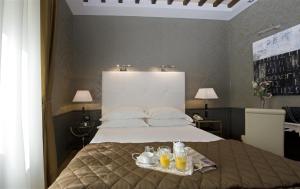 罗马杜卡德阿尔巴酒店的一间卧室配有一张床,并备有饮料托盘
