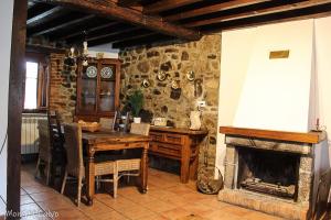 Soto De AguesCasa Rural El Puente de Agues的一间带桌子和壁炉的用餐室