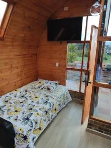 派帕Glamping VILLA - Nueva en Paipa的一间卧室配有一张床和一台平面电视