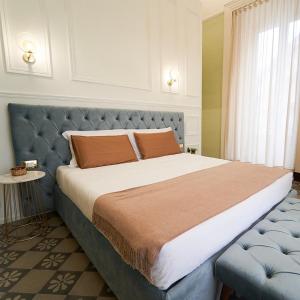 卡塔尼亚Toscano Palace Luxury Rooms Catania的一间卧室配有一张大床和蓝色床头板