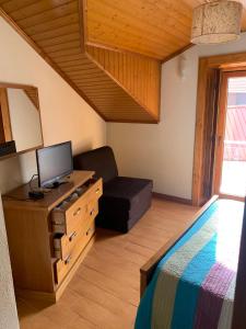 萨布盖鲁Recantos da Estrela的一间卧室配有一张床、一台电视和一把椅子