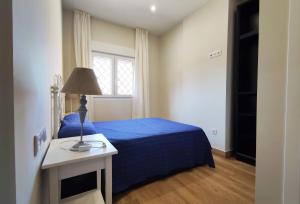 桑卢卡尔-德巴拉梅达APARTAMENTOS SANLUCAR CASA C的一间卧室设有蓝色的床和窗户。