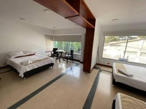 麦德林Apartamento privado en Medellin MAG301的一间卧室配有一张床、一张桌子和一个窗户。