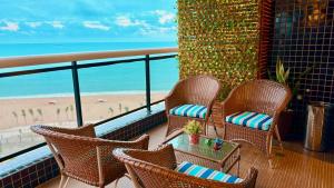 福塔莱萨LANDSCAPE - Beira mar platinum的一个带椅子的阳台,享有海滩美景
