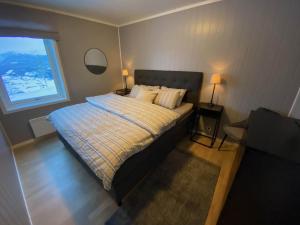 斯屈勒斯塔穆New modern apartment with great view - ski in & out的一间卧室配有一张带两盏灯的床和一扇窗户。