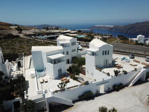 易莫洛林Athiri Santorini Hotel的享有白色建筑的空中景色,背景是大海