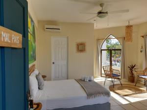 塔马林多Zulu Surf Hotel Tamarindo的卧室配有一张床和一张桌子及椅子
