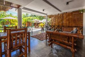 龙目岛库塔马尔塔斯温多斯酒店的一间带长椅和桌子的房间以及庭院