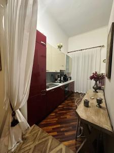 克罗托内Estes的铺有木地板的厨房配有红色橱柜