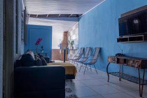 库亚巴Casa c ótima localização piscina e WiFi, Cuiabá的客厅拥有蓝色的墙壁,配有沙发和椅子