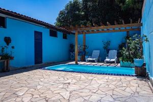 库亚巴Casa c ótima localização piscina e WiFi, Cuiabá的一个带两把椅子的游泳池以及一间蓝色的房子