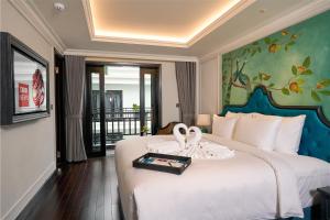 会安Hoi An Delicacy Hotel & Spa的酒店客房,配有一张带两个天鹅的床