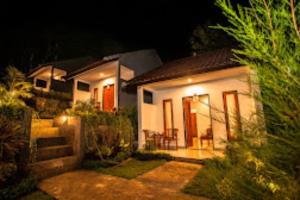 珀尼达岛Singgahan Bungalow by ecommerceloka的夜晚有灯的小白色房子