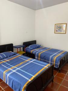Pueblo BelloLa Casa de Luzma的配有蓝色和黄色床单的三张床