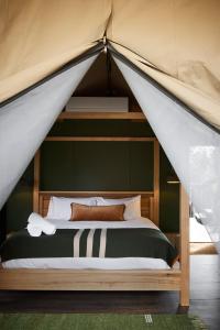 梅顿Metung Hot Springs的帐篷内一间卧室,配有一张床