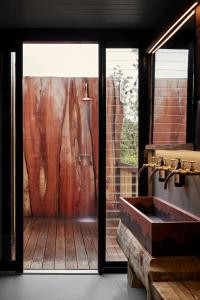 梅顿Metung Hot Springs的带淋浴、水槽和玻璃门的浴室