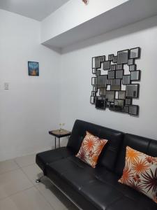 马尼拉Sea Residences MOA Complex - Ruffa's Condotel的客厅配有黑色沙发和桌子