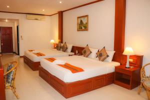 邦涛海滩Andaman Seaside Resort - SHA Extra Plus的一间卧室配有两张床和一张桌子及椅子
