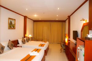 邦涛海滩Andaman Seaside Resort - SHA Extra Plus的酒店客房设有两张床和电视。