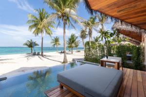 丽贝岛Irene Pool Villa Resort, Koh Lipe的一个带游泳池和棕榈树海滩的度假胜地