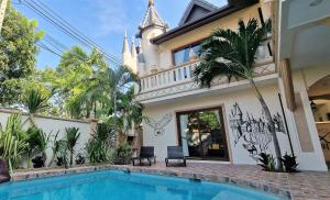 南芭堤雅POTTERLAND Luxury Pool Villa Pattaya Walking Street 6 Bedrooms的大楼前带游泳池的房子