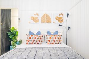 悉尼Bondi Boho House Jacuzzi PoolSpa HolidayRento的一间卧室配有带橙色和蓝色枕头的床