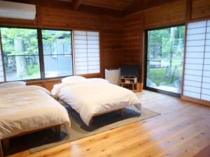 山中湖村Forest Villa Yamanakako的带窗户的客房内的两张床