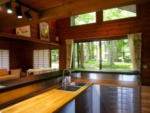 山中湖村Forest Villa Yamanakako的一个带水槽和大窗户的厨房